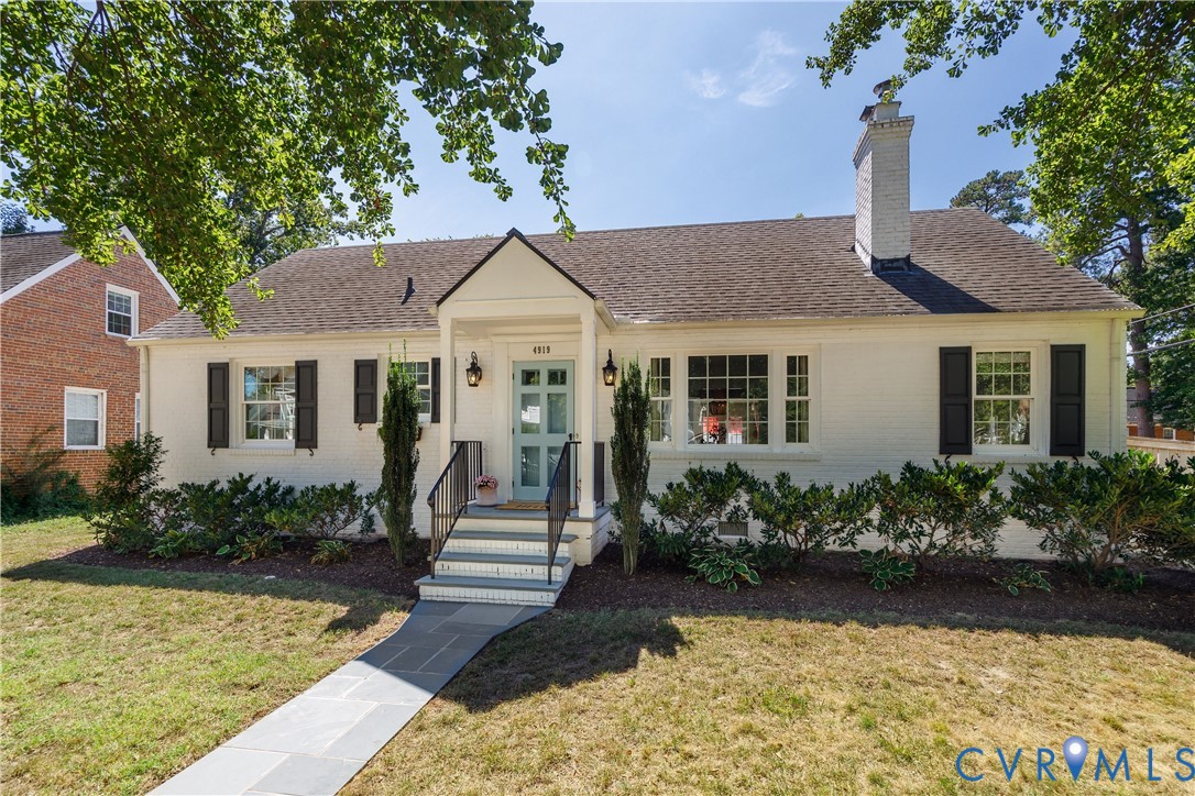 White painted brick exterior with black window shutters