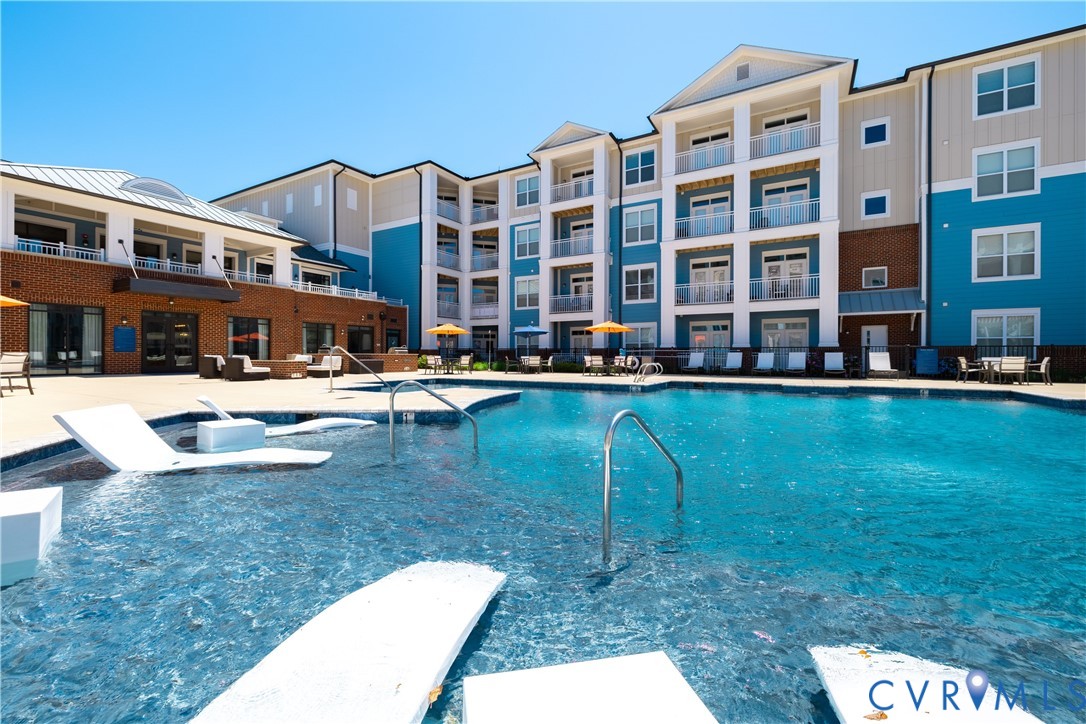 Outdoor aquatic amenity with integrated lounging areas and surrounding hardscaping Outdoor aquatic amenity with integrated lounging areas and surrounding hardscaping