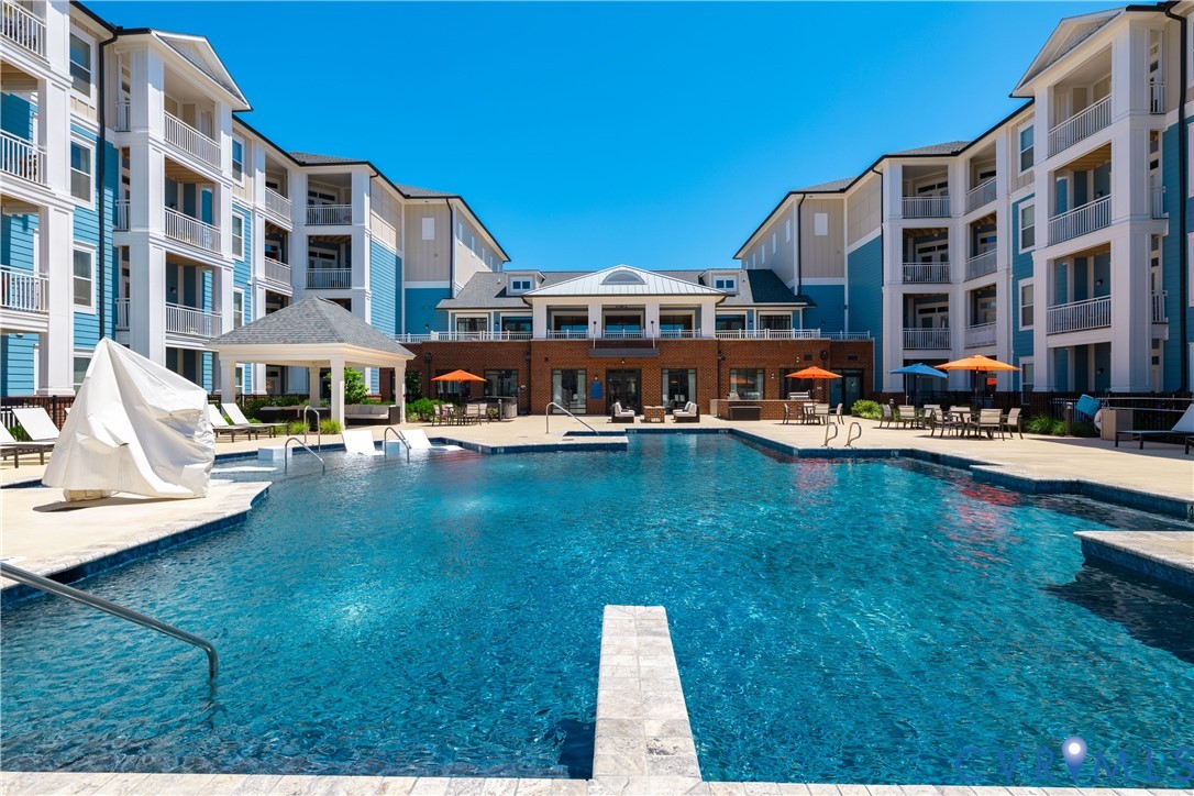 Expansive outdoor pool with integrated water features, surrounded by a paved deck Expansive outdoor pool with integrated water features, surrounded by a paved deck