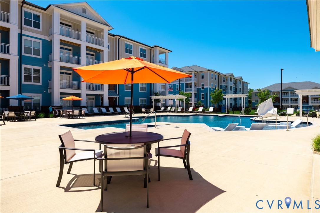 Expansive pool deck with an outdoor swimming pool, lounge seating, and multiple outdoor tables Expansive pool deck with an outdoor swimming pool, lounge seating, and multiple outdoor tables
