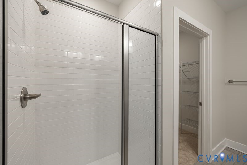 Shower with subway tile surround, glass enclosure, and brushed nickel fixtures
