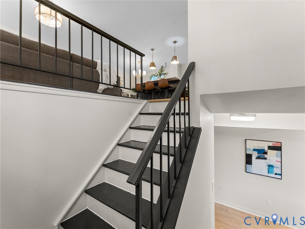 Staircase with black risers and white treads, featuring a black metal balustrade