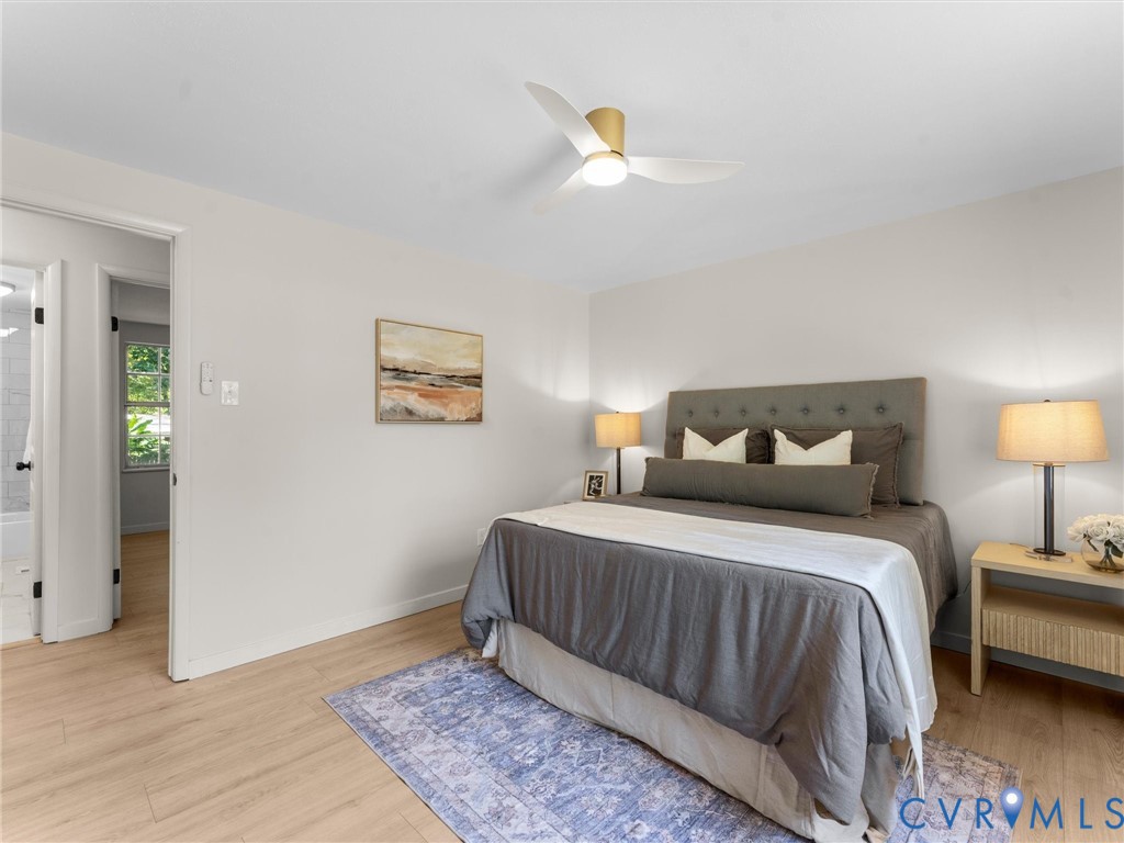 Light-toned wood-finish flooring, a contemporary ceiling fan with integrated lighting, and a neutral color palette