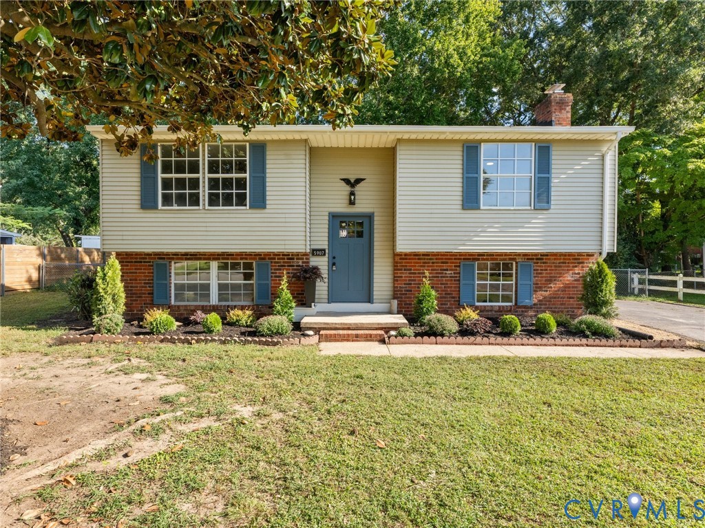 Two-story exterior featuring brick and siding finishes, a prominent front door with a transom window, and multiple paneled windows with decorative shutters