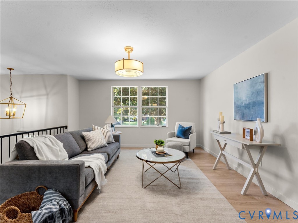 Light-colored wood-finish flooring, white walls, and a large window with muntins