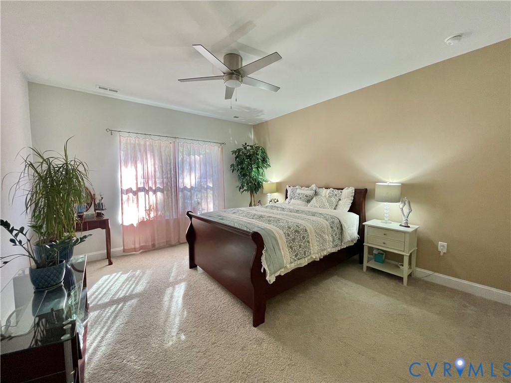Recessed ceiling, neutral carpet flooring, and a ceiling fan