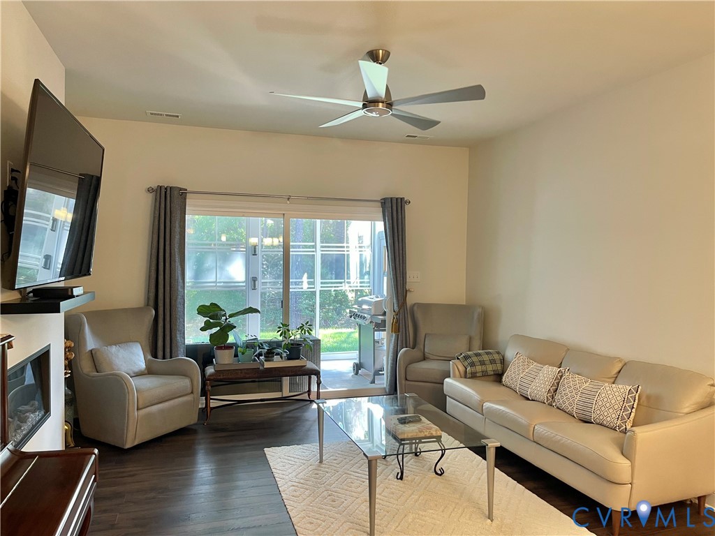Built-in fireplace, wood-finish flooring, ceiling fan, and sliding glass door