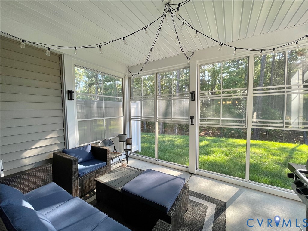 Screened-in porch with concrete flooring, vaulted ceiling, and exterior siding