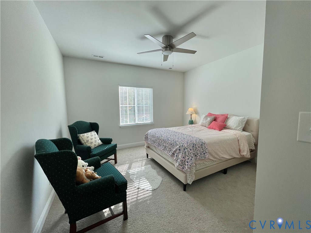 Carpeted room with a ceiling fan, window with blinds, and white walls