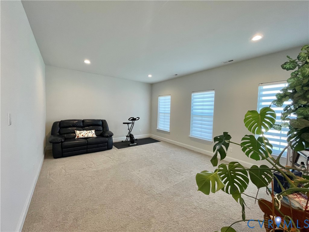 Neutral wall paint, recessed lighting, and carpeted flooring