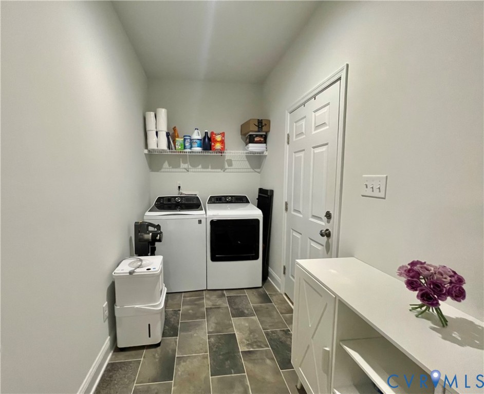 Utility room featuring slate-style floor tiling, wire shelving, and a paneled door