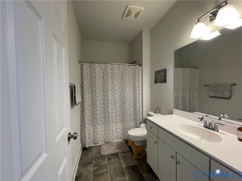 White vanity with dual-door cabinetry, integrated sink, and chrome faucet