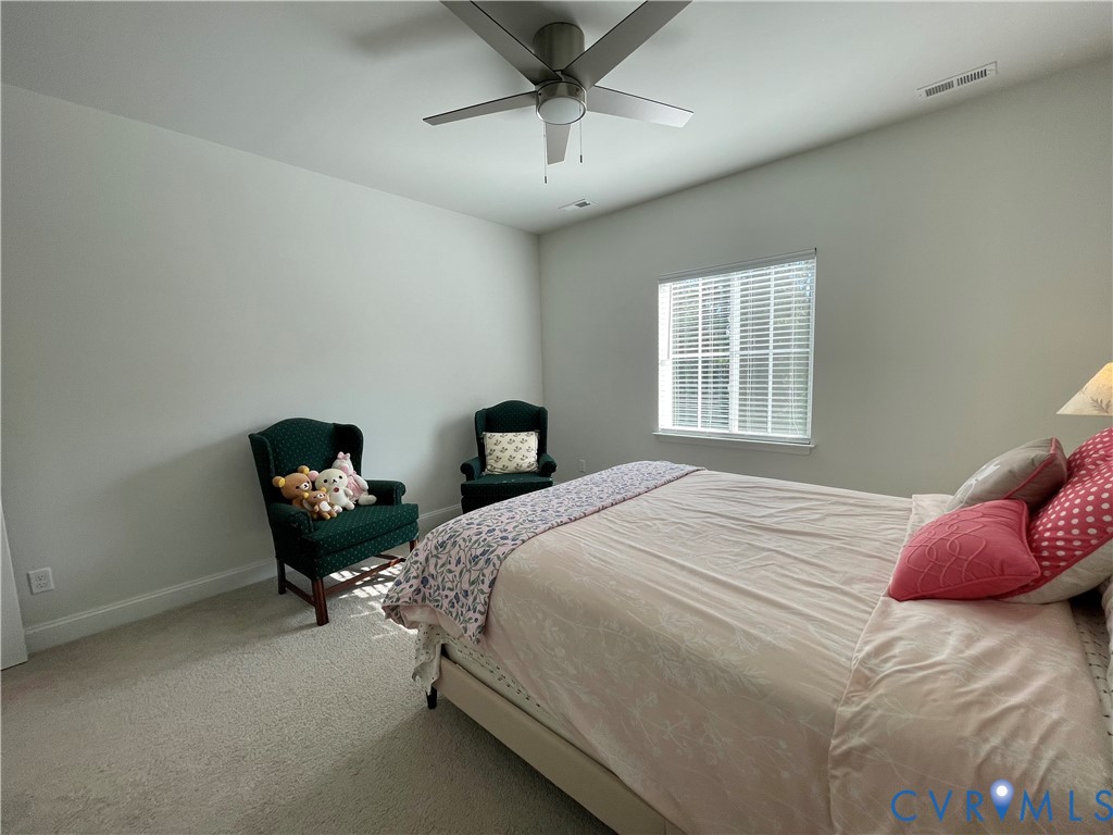 Carpeted flooring, window with blinds, ceiling fan with integrated lighting, recessed lighting, and light neutral wall tones