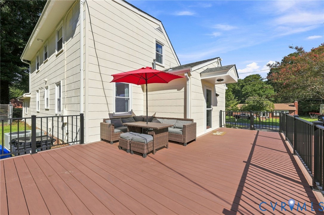 Expansive new deck with composite decking, black metal railings, and direct exterior access