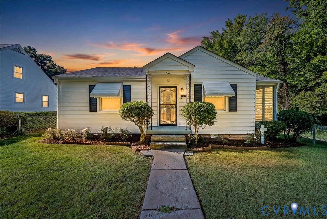 White siding exterior with black shutters and window awnings