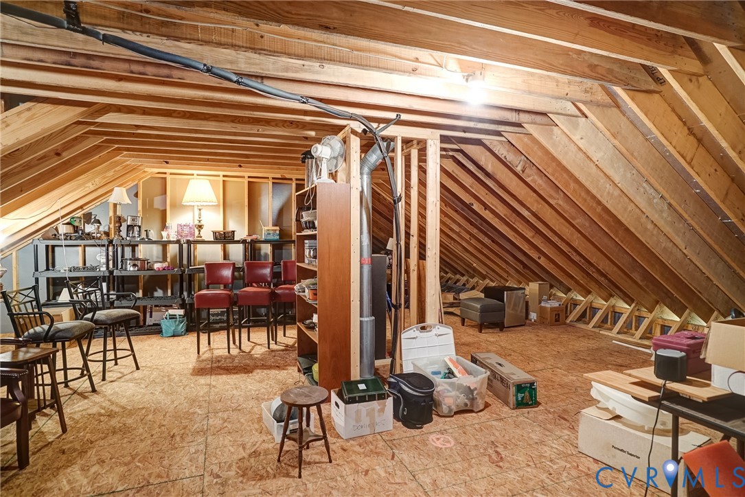 Exposed wood beam ceiling, unfinished wood flooring, and structural framing