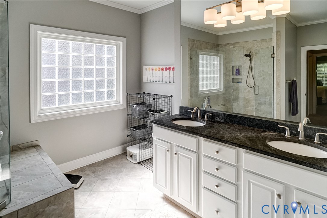 Dual vanity with dark countertop, white cabinetry, and undermount sinks