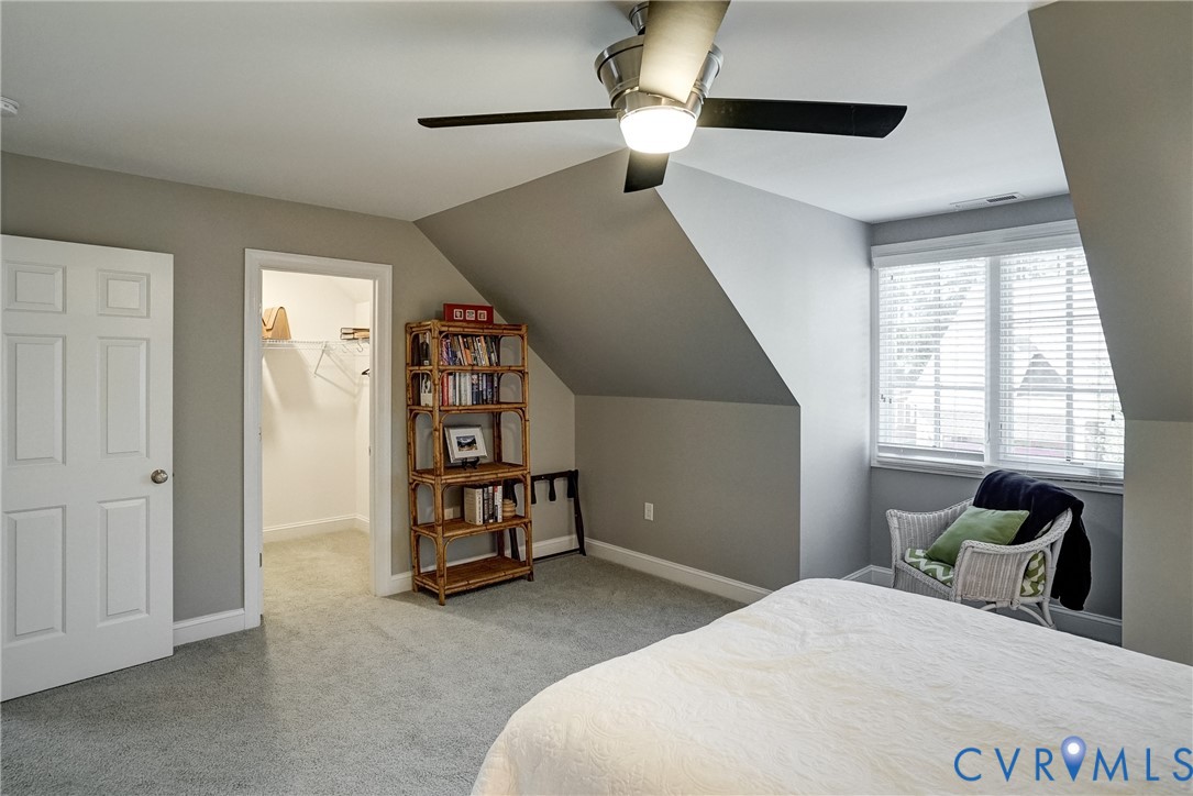 Sloped ceilings with recessed lighting, ceiling fan, carpet flooring, window with blinds, and walk-in closet with shelving