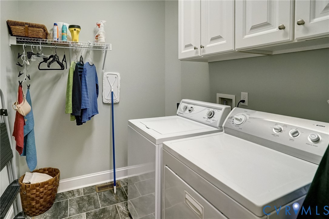 Laundry area featuring overhead cabinetry, a wire shelving system, and tiled flooring