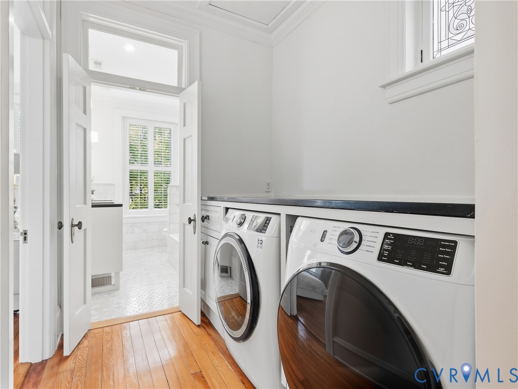 Hardwood flooring, built-in newer laundry appliances, black countertop convenient for folding.