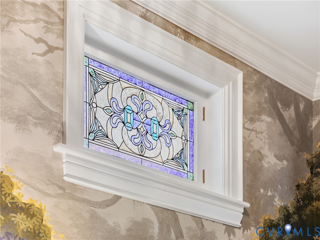 Decorative stained glass window with white trim, framed by a painted wall mural and crown molding