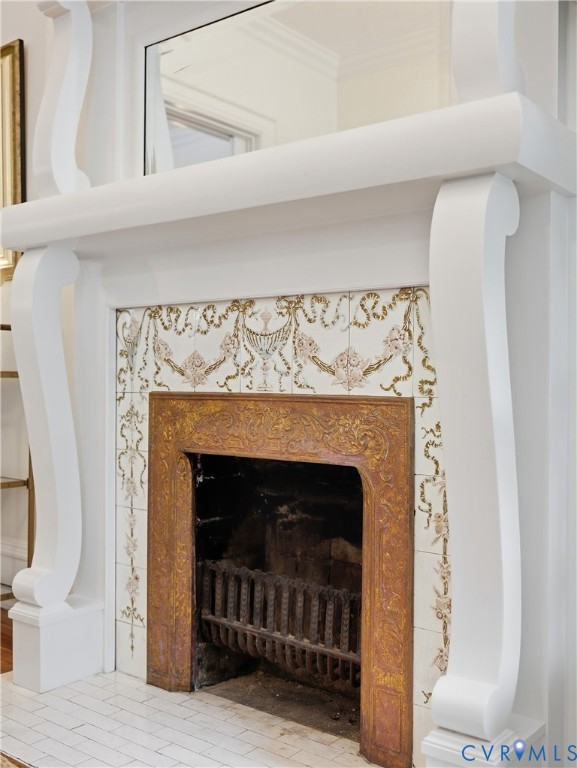 White mantel with scrolled corbels, decorative tile surround, and cast iron firebox