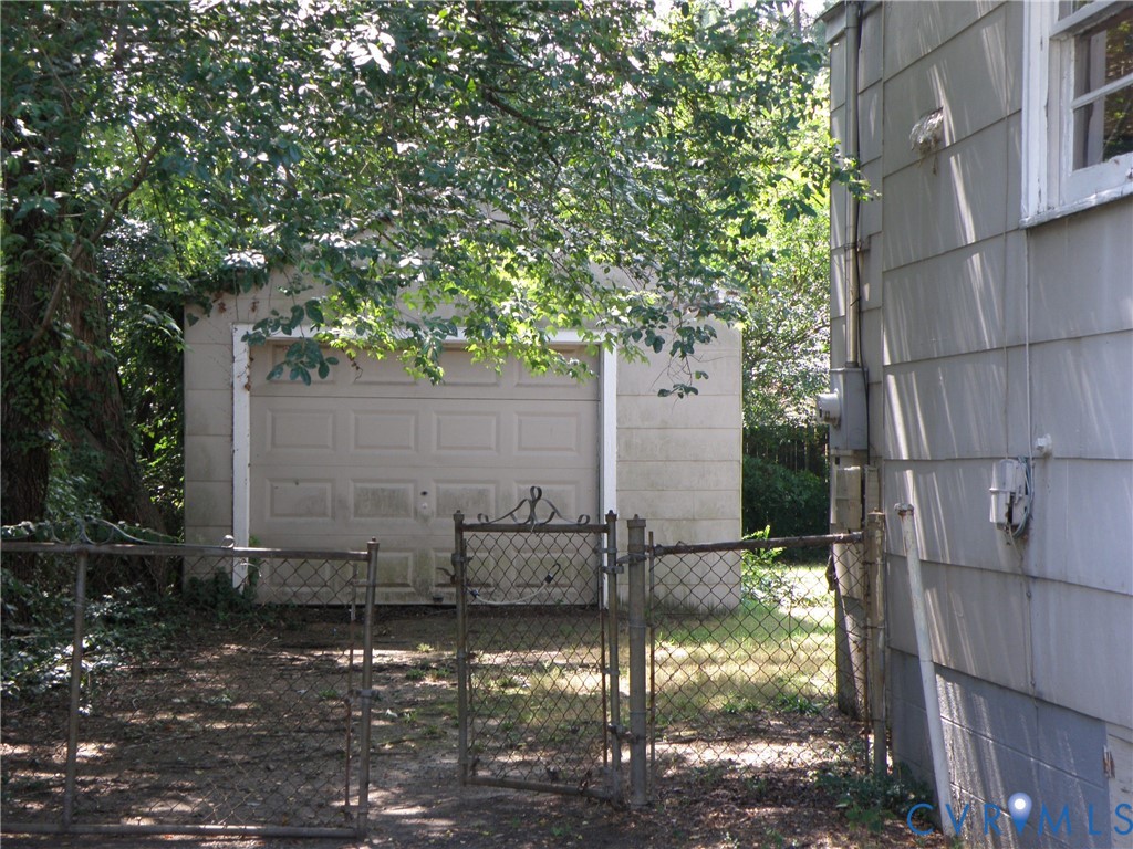 Detached garage with overhead door inside fenced backyard Detached garage with overhead door inside fenced backyard