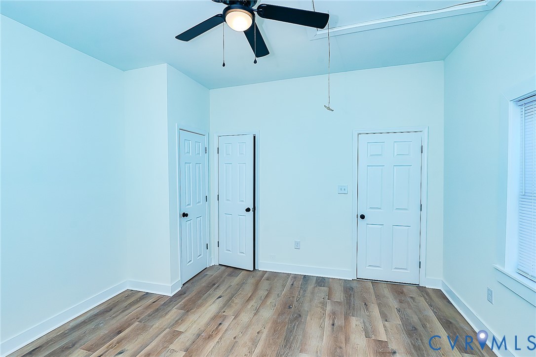 LVP flooring with white trim, a ceiling fan, and white paneled doors