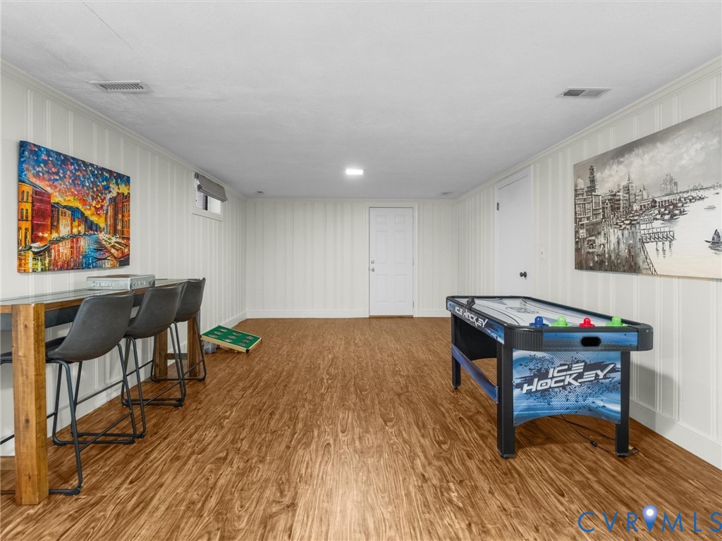 Wood-finish flooring, white panel walls, and recessed lighting