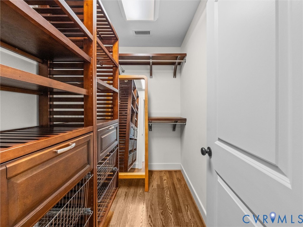 Custom closet system featuring wood-finish shelving, integrated drawers, wire baskets, and hanging rods