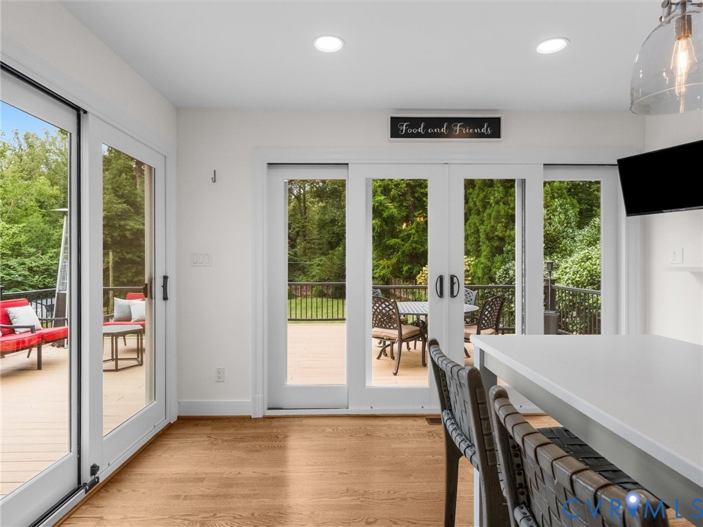 Hardwood flooring, recessed ceiling lighting, and sliding glass doors providing outdoor access