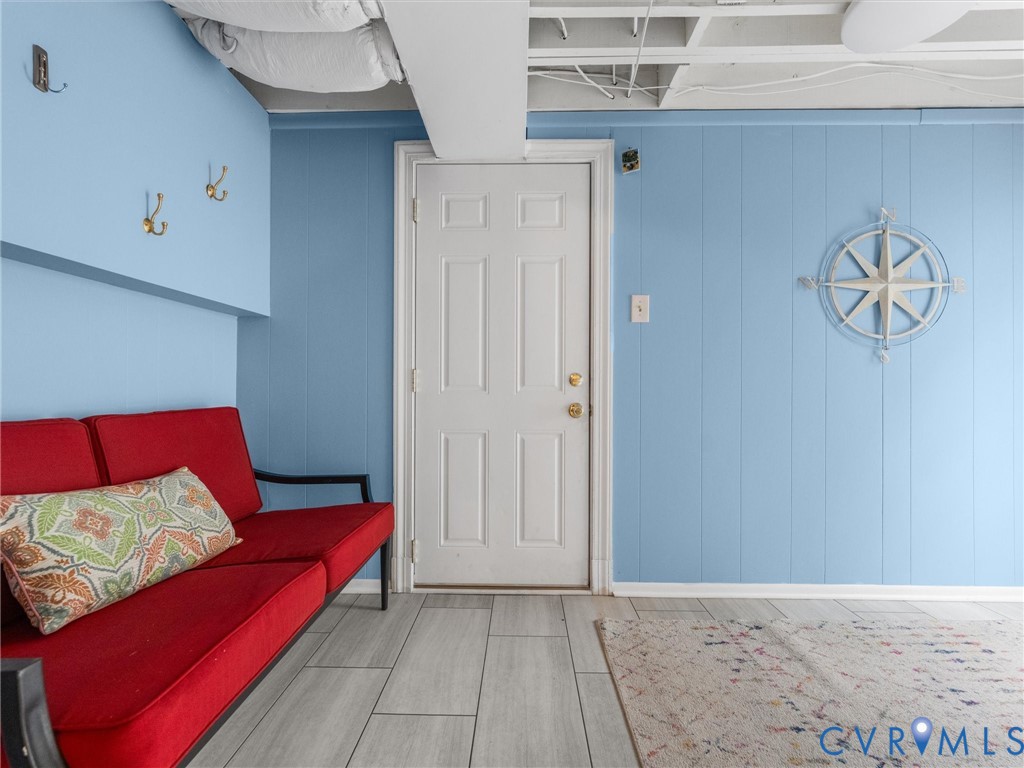 Light blue paneling, wood-finish flooring, and a solid core door