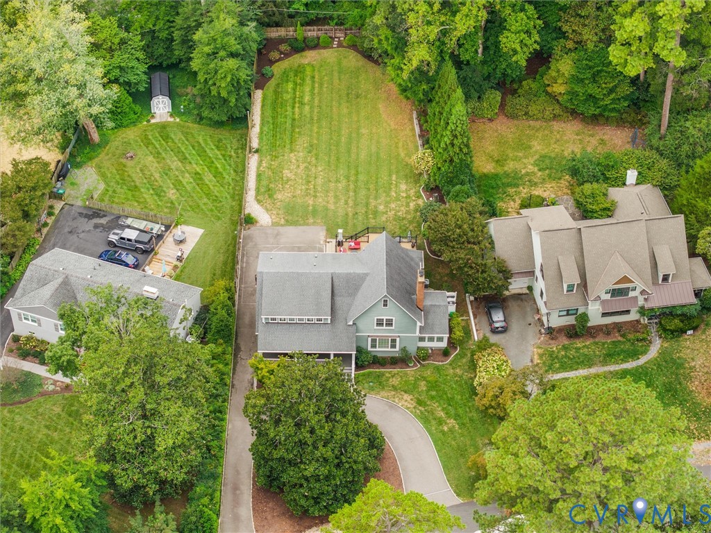 Expansive residential property featuring multiple structures, mature trees, manicured lawns, and paved driveways