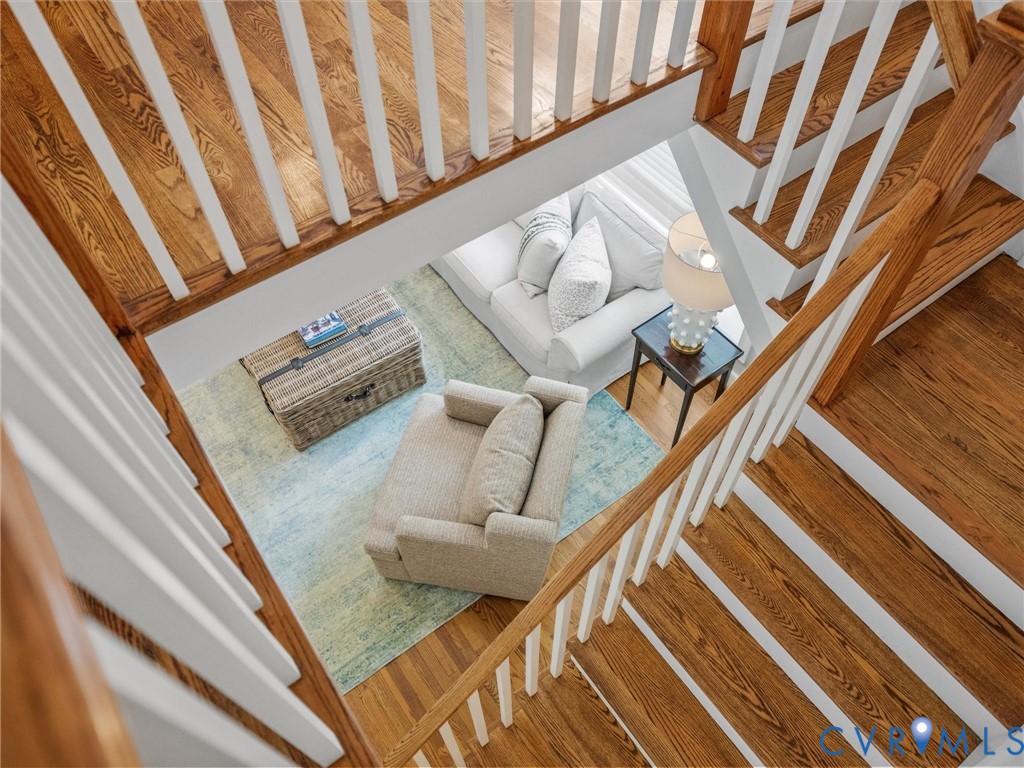 Hardwood staircase with white balusters and wooden handrails