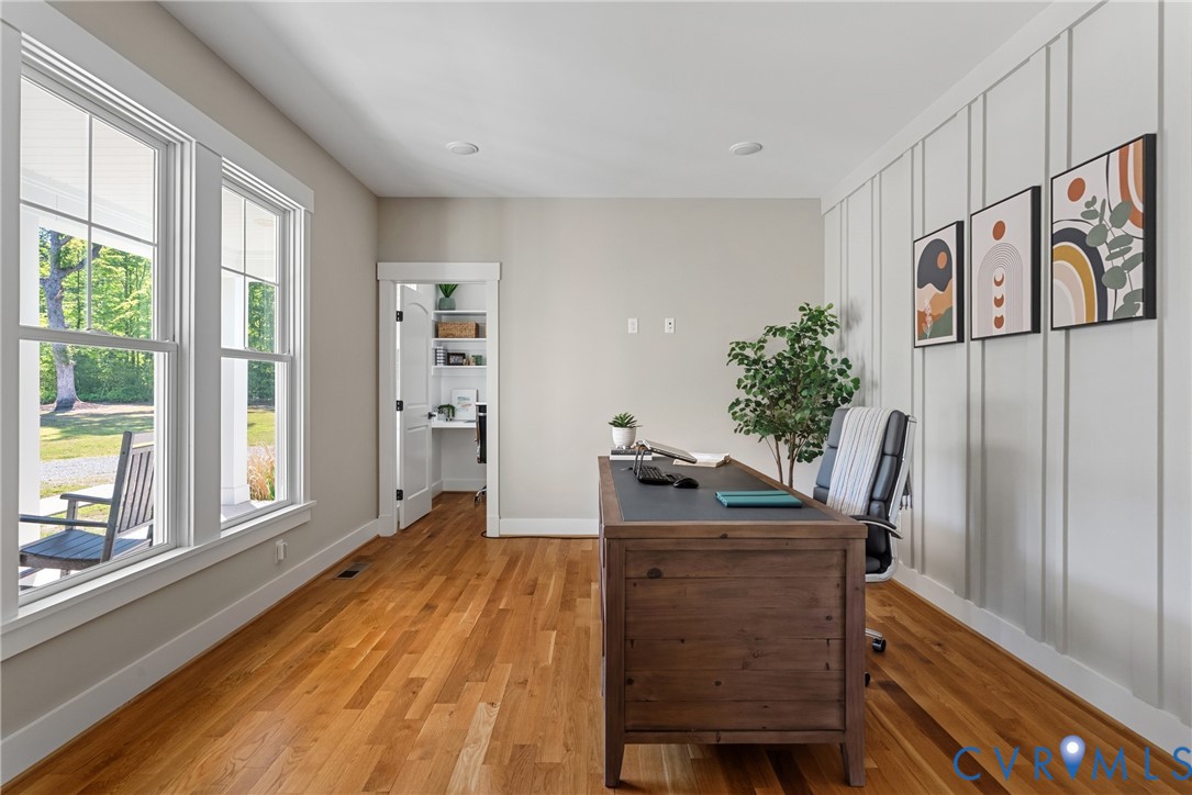 Hardwood flooring, abundant natural light from large windows, recessed lighting, and a built-in organizational nook