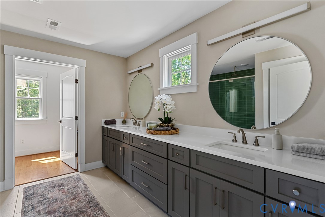 Dual vanity with gray cabinetry and white countertops