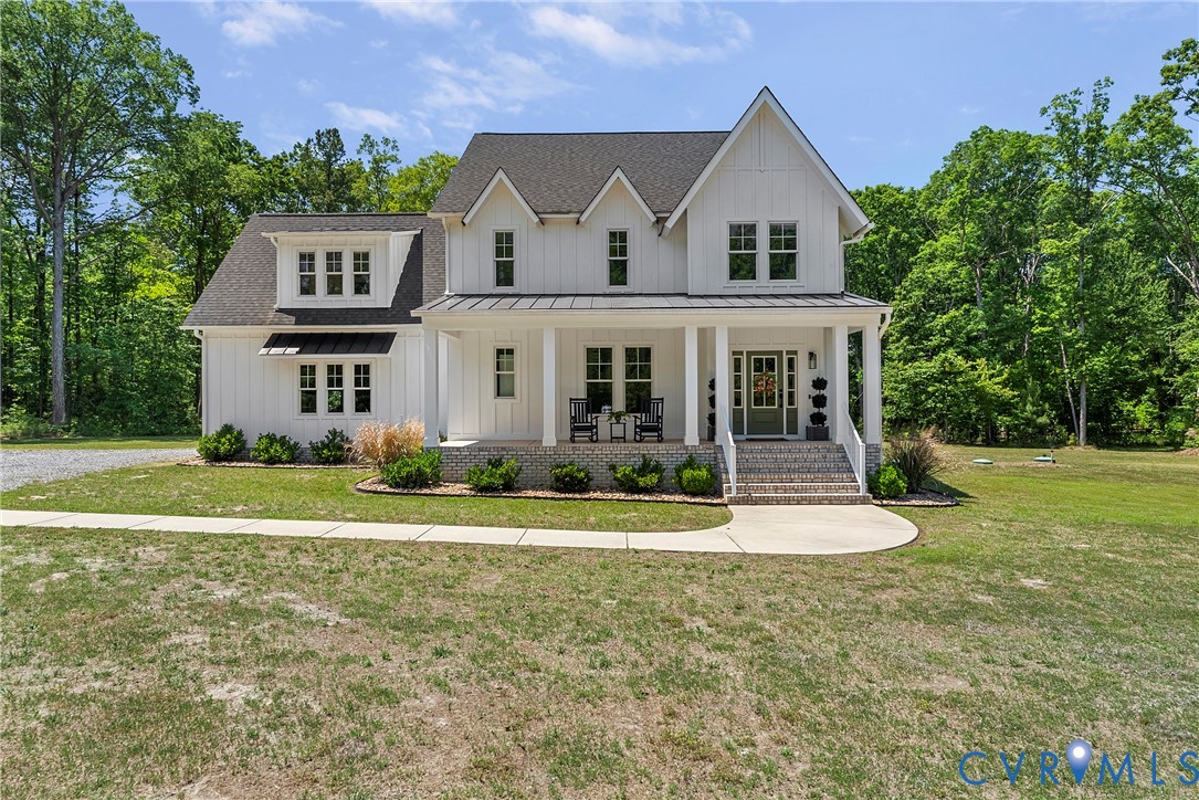 Farmhouse-inspired exterior with white board-and-batten siding and dark-shingle roofing Farmhouse-inspired exterior with white board-and-batten siding and dark-shingle roofing