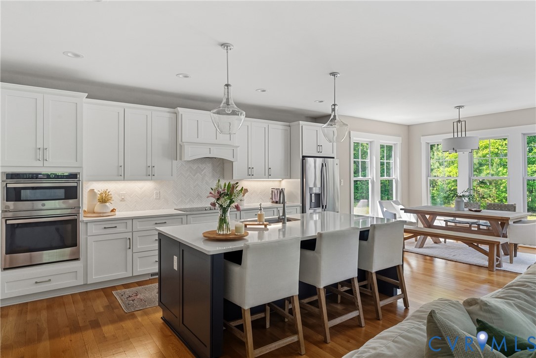 Gourmet kitchen with white cabinetry, stainless steel appliances, and a central island with a quartz countertop