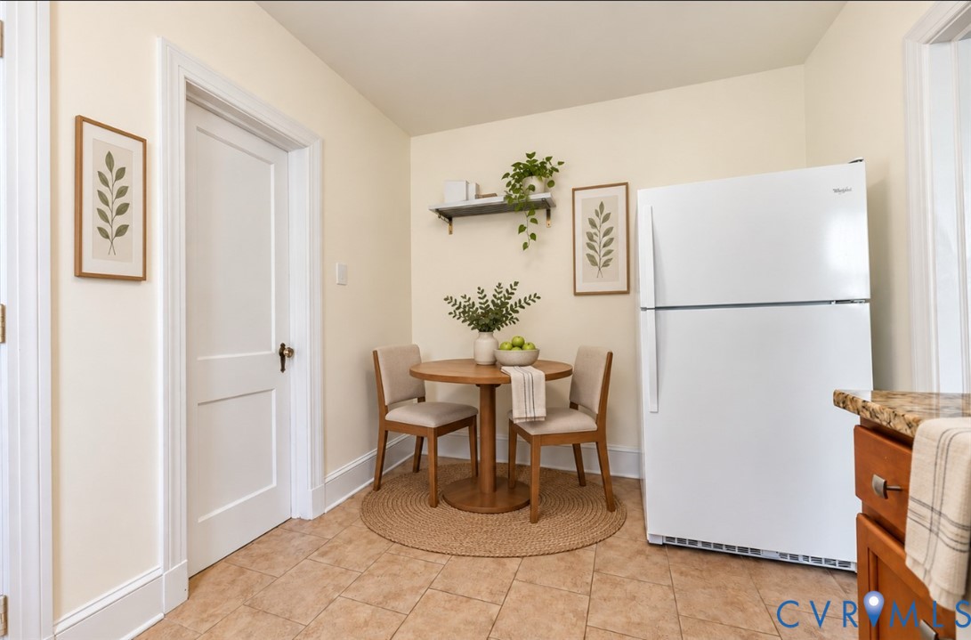 Tile flooring, light-toned walls, white two-panel interior door, baseboard and door trim, built-in shelving