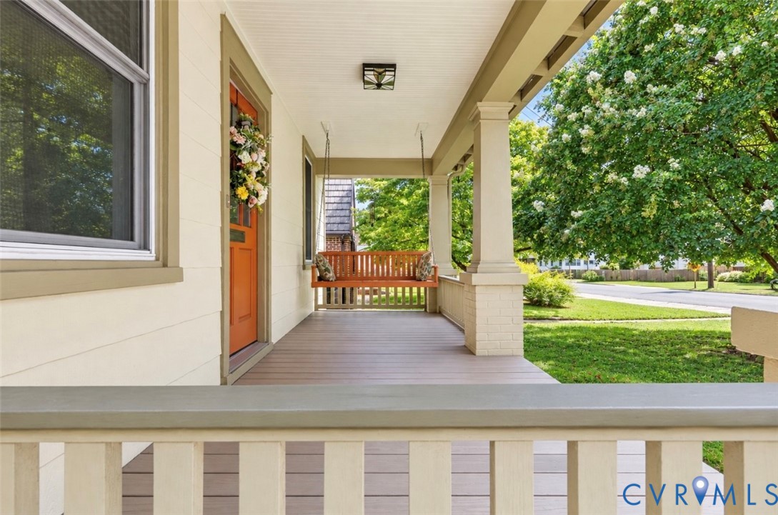 Expansive front porch featuring wood-finished lporch, architectural columns with brick bases, and a beadboard ceiling