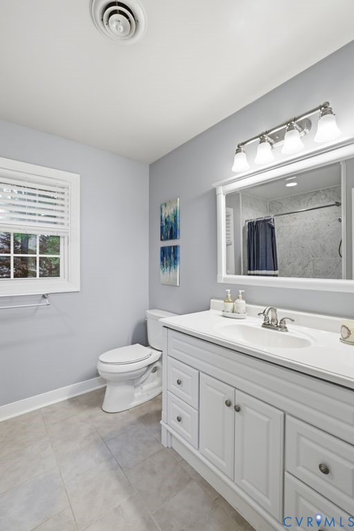 Bathroom featuring a white vanity with integrated sink, chrome faucet, and a large framed mirror