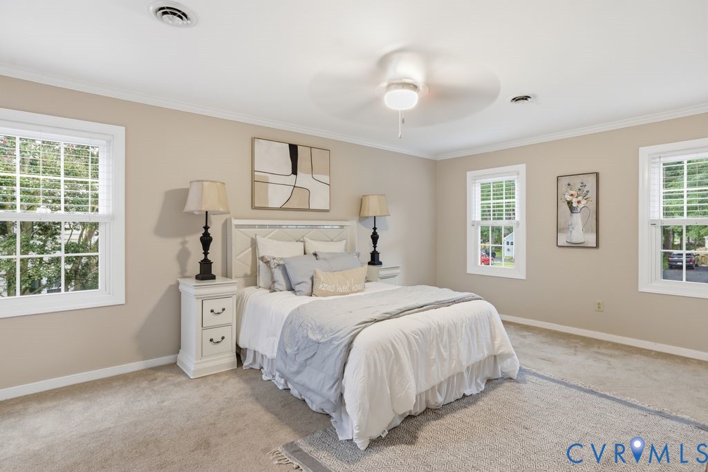 Spacious room featuring neutral wall tones, white trim, and light-toned carpeting