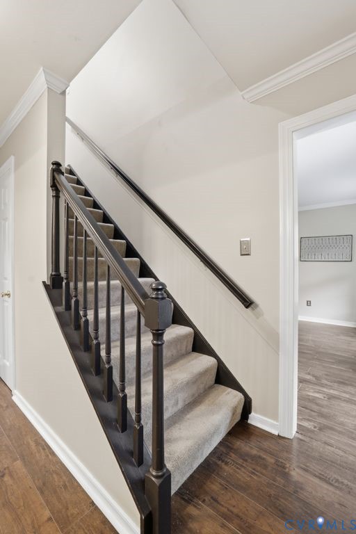 Staircase featuring dark wood newel posts, balusters, and handrails