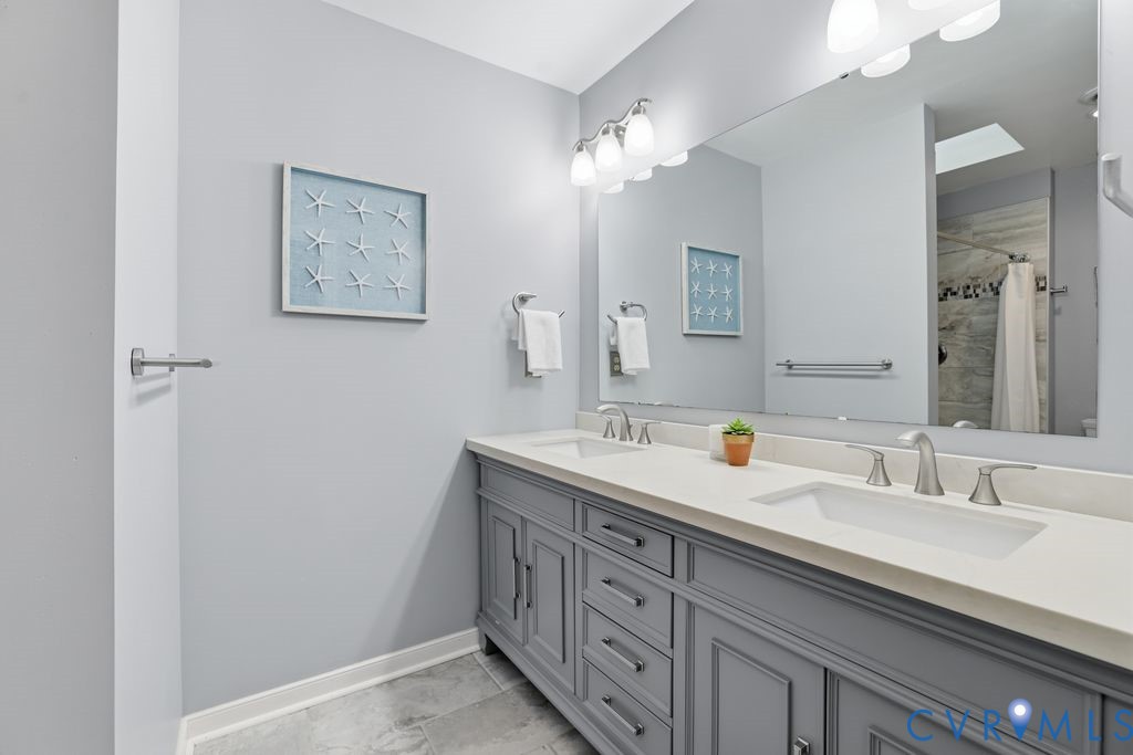 Double vanity featuring grey cabinetry, white countertops, and brushed nickel fixtures