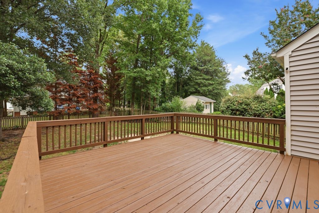 Spacious outdoor deck with wood railing and natural wood-finish decking