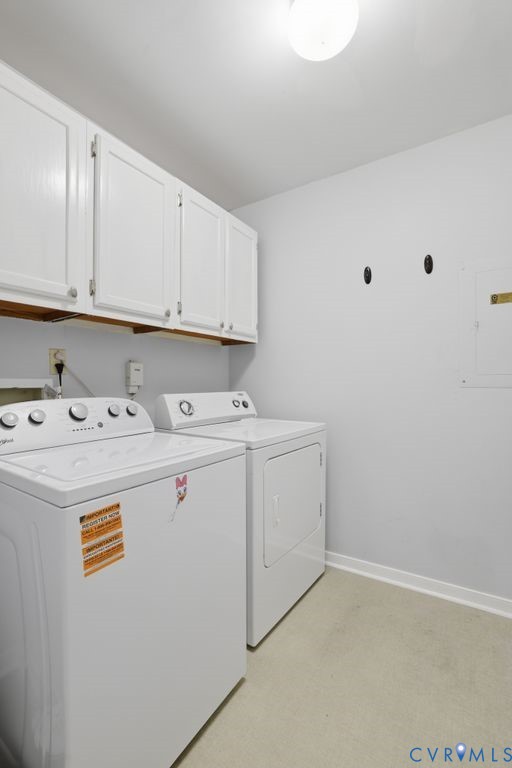 Dedicated laundry area featuring white upper cabinetry, a flush-mount ceiling light, light-toned flooring, and white baseboards
