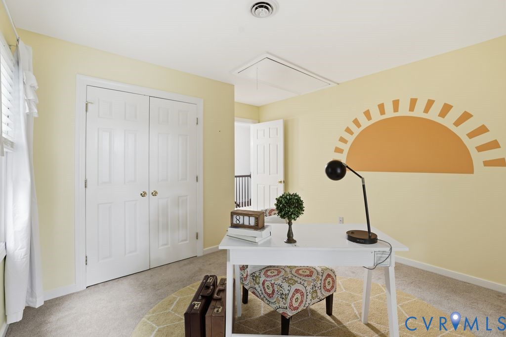 Room featuring neutral-toned walls, light-colored carpet flooring, a window with white blinds, and a double-door closet