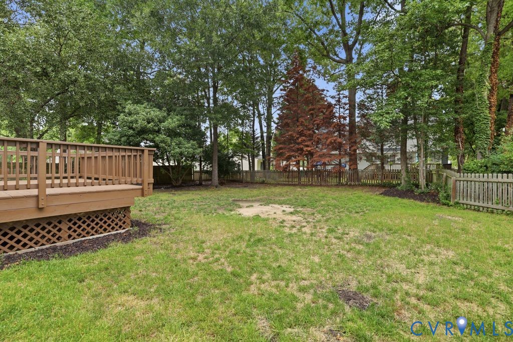 Expansive outdoor deck with lattice skirting, surrounded by mature trees