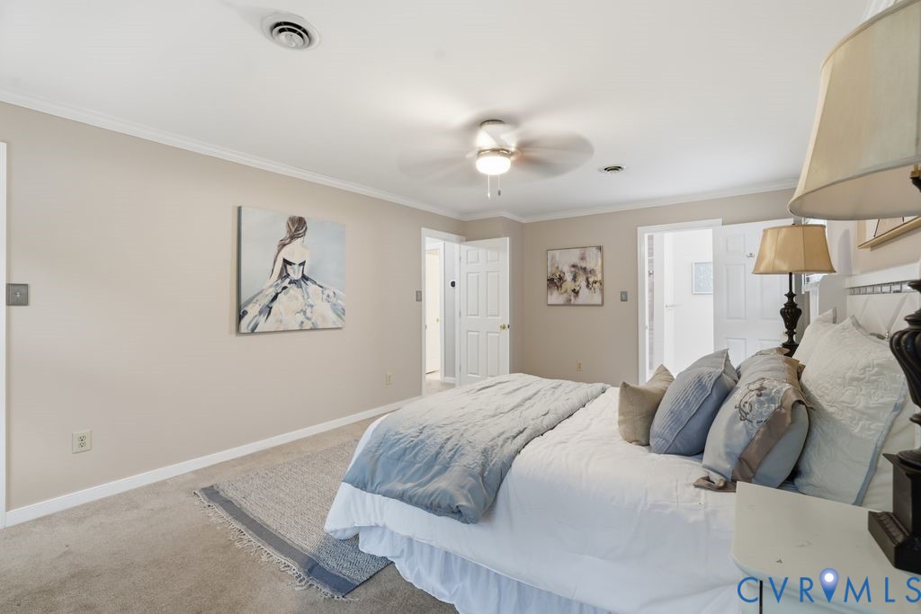 Carpeted room featuring a ceiling fan, recessed lighting, crown molding, and two white paneled doors