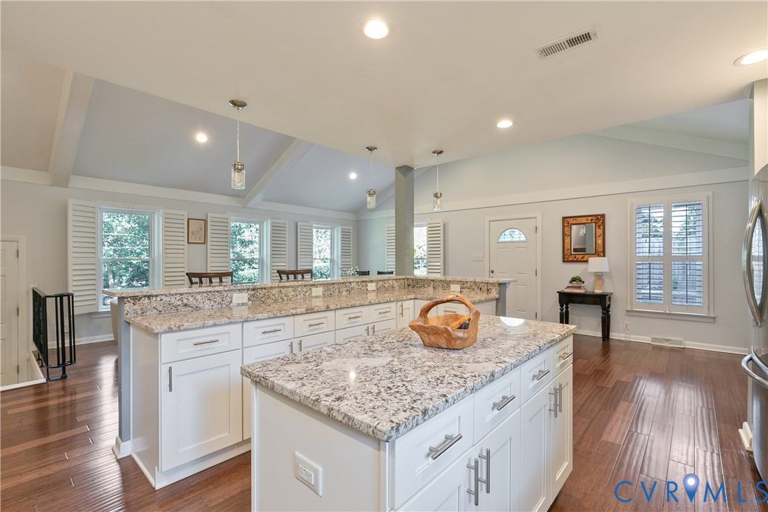Vaulted ceilings, recessed lighting, and wood-finish flooring